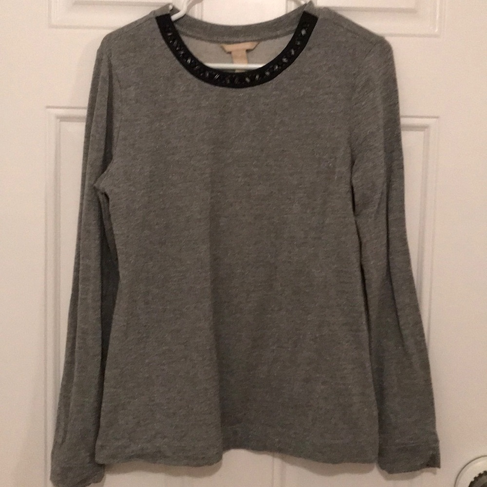 Metallic silver top with neckline embellishment.